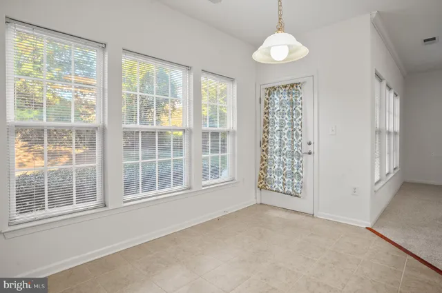 a view of kitchen with refrigerator cabinets and window