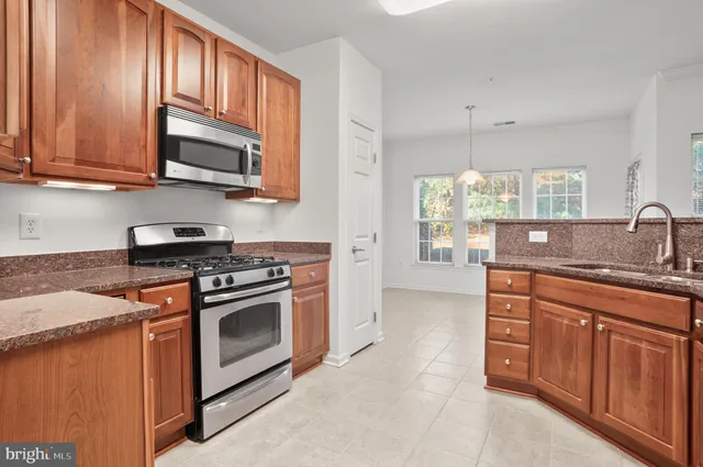 a kitchen with stainless steel appliances granite countertop a sink stove and microwave