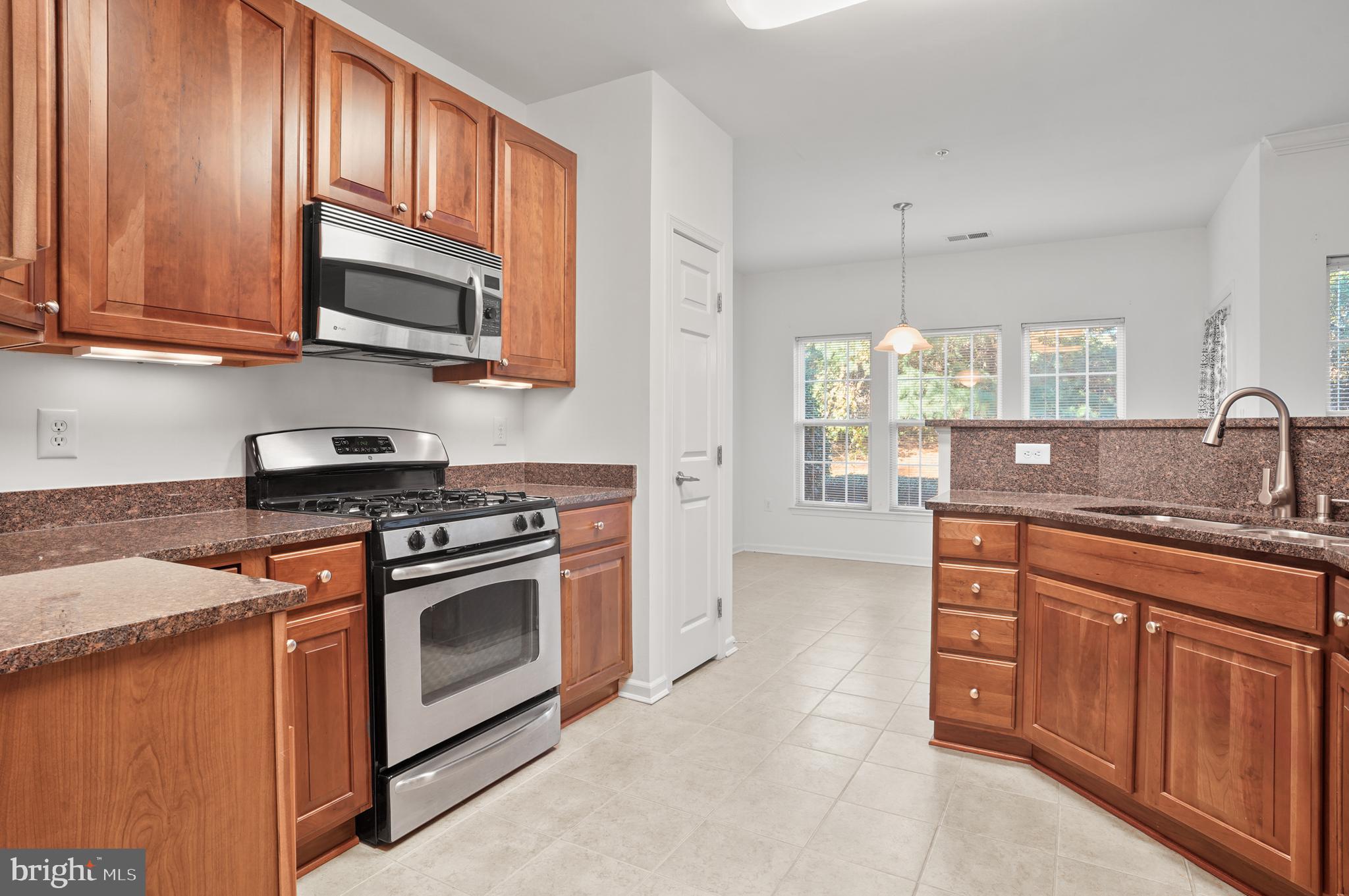 1014 Samantha Lane, Unit 102 Odenton, MD 21113 - Photo 3 of 32 a kitchen with stainless steel appliances granite countertop a sink stove and microwave