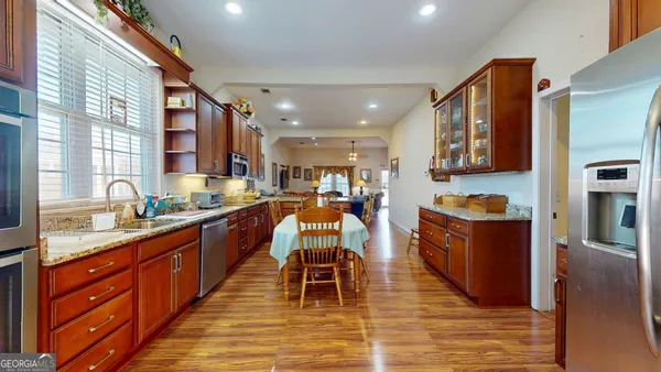 a large kitchen with stainless steel appliances kitchen island granite countertop a large island in the center
