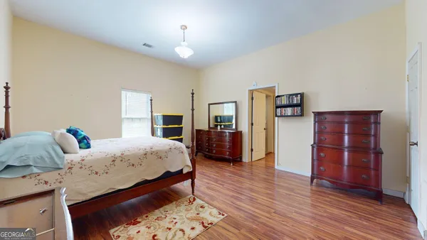 a bedroom with bed and wooden floor