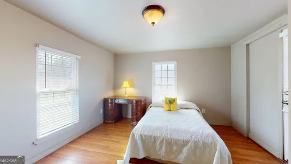 a bedroom with a bed and wooden floor