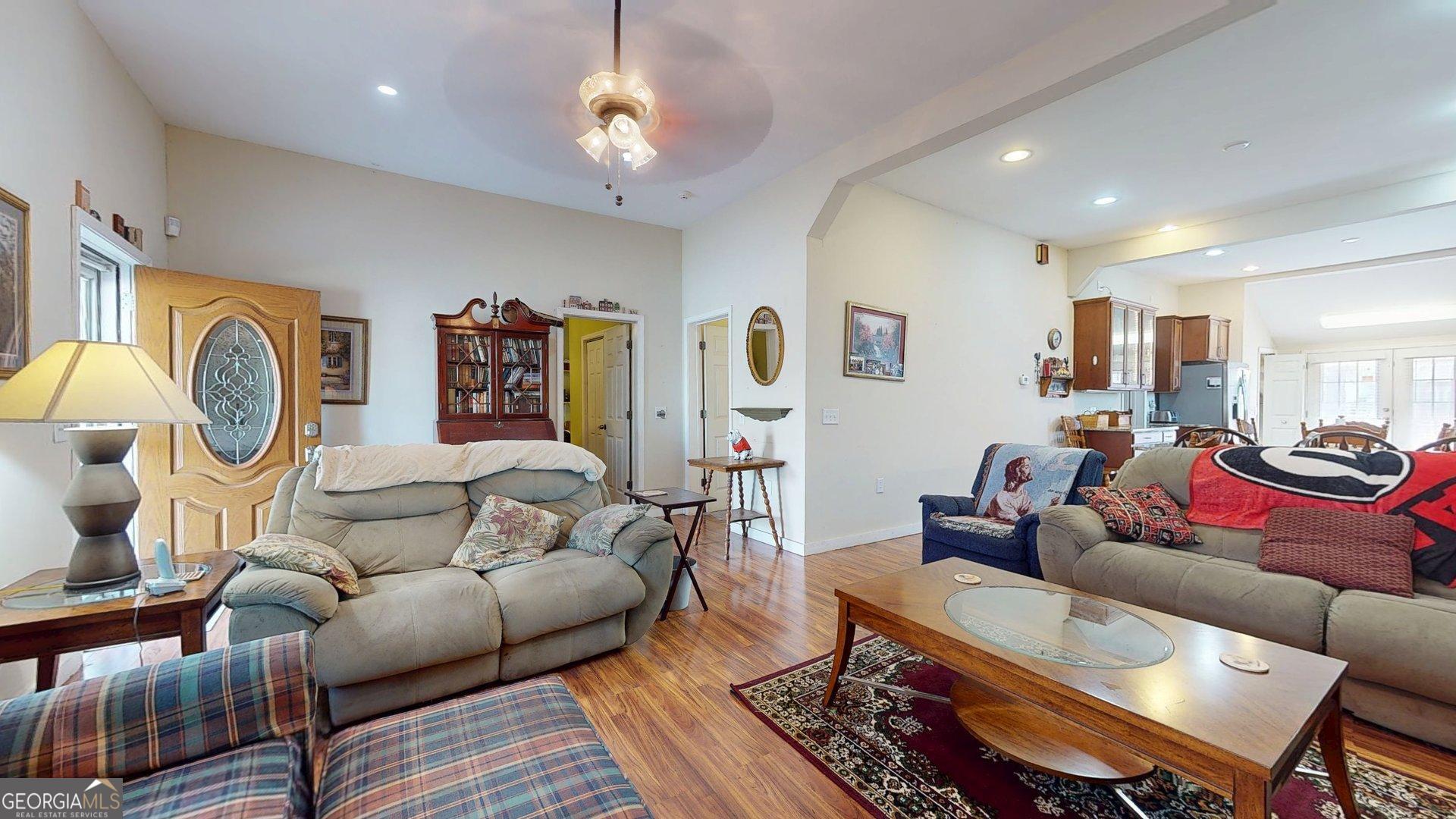 297 North Rountree Street Metter, GA 30439 - Photo 9 of 34 a living room with furniture a wooden floor and a chandelier