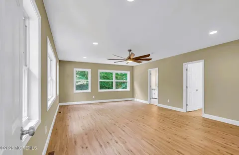 a view of a hallway with wooden floor and closet area