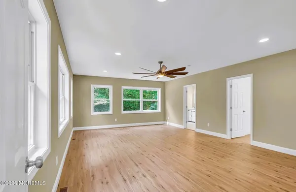 a view of a hallway with wooden floor and closet area