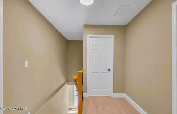 a view of an empty room with wooden floor and windows