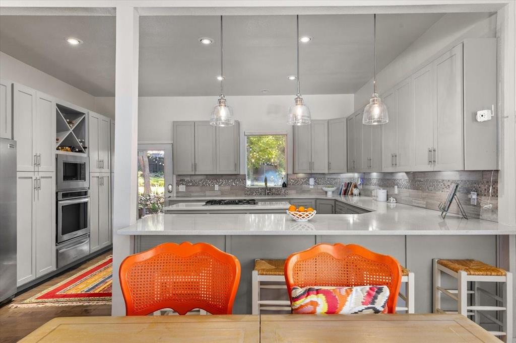 6121 Sharon Road Fort Worth, TX 76116 - Photo 16 of 37 a view of a kitchen with stainless steel appliances kitchen island granite countertop a large kitchen island a chandelier and living room view