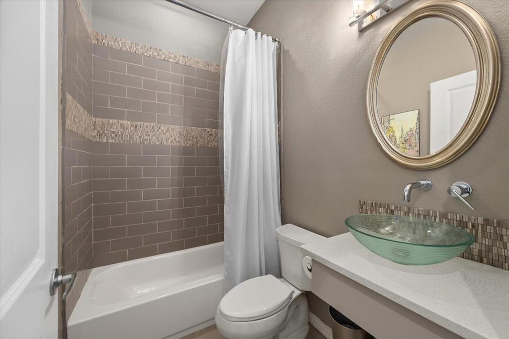 6121 Sharon Road Fort Worth, TX 76116 - Photo 29 of 37 a bathroom with a sink a toilet and a mirror