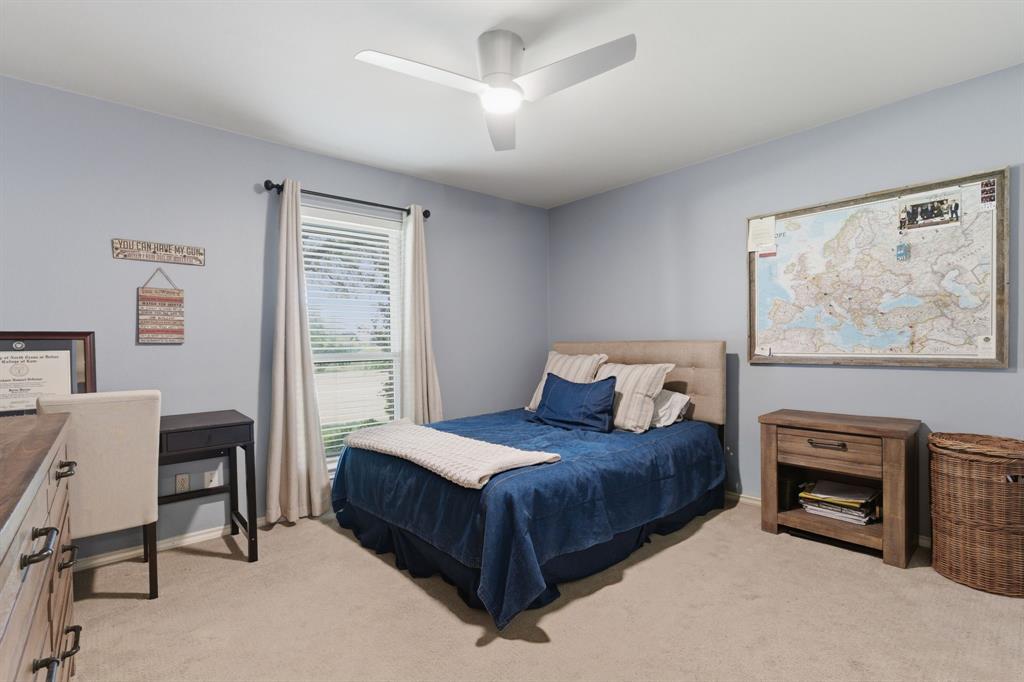 10390 Ridgecrest Street Frisco, TX 75033 - Photo 30 of 40 a bedroom with a large bed a chandelier and a fireplace