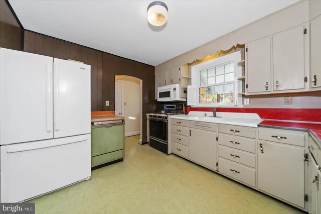 a kitchen with cabinets stainless steel appliances and a window