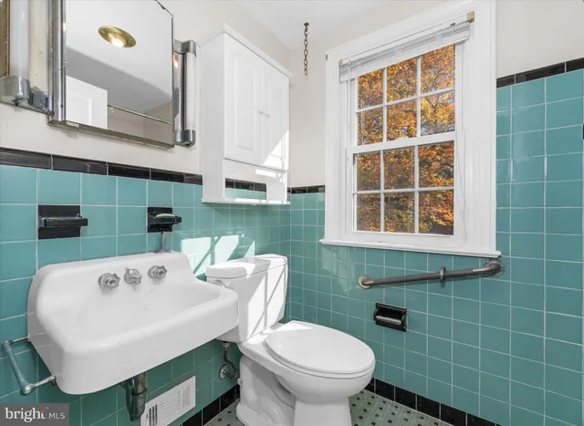 a bathroom with a sink a toilet and a mirror