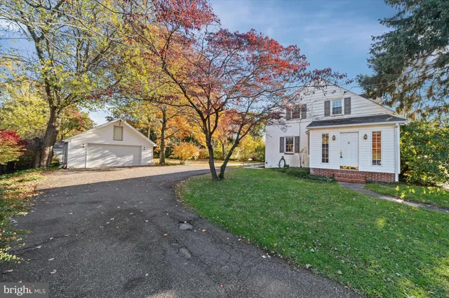 a front view of a house with a garden and trees