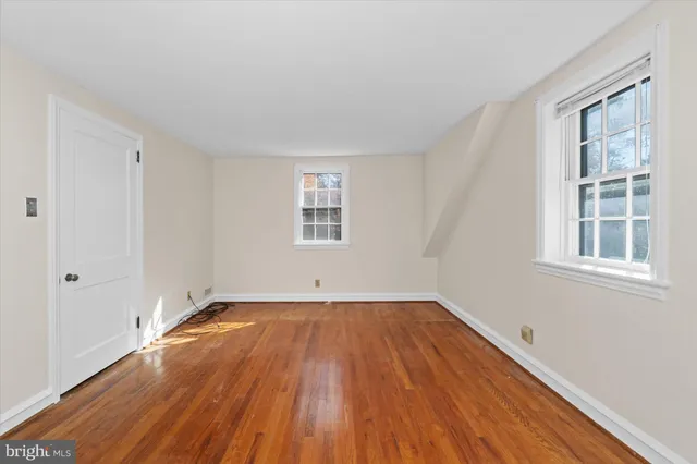 a view of a room with wooden floor and windows