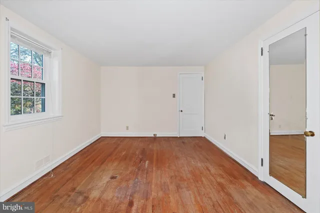 a view of a room with wooden floor and window