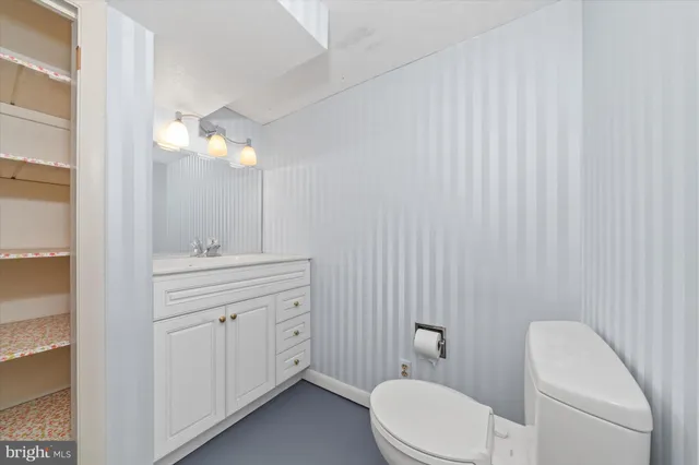 a bathroom with a toilet a sink a mirror and vanity