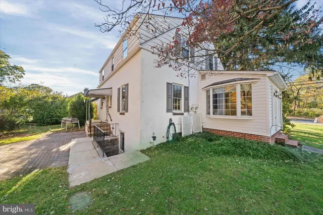 a front view of house with yard and trees in the background