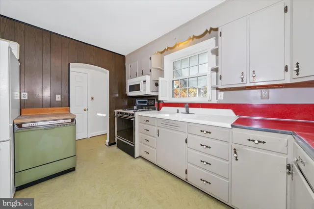 a kitchen with cabinets appliances and a window