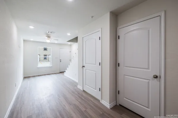 an empty room with wooden floor and windows