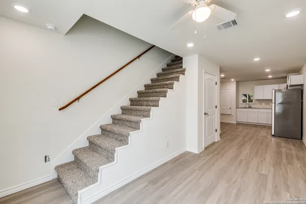 a view of a hallway with wooden floor and staircase