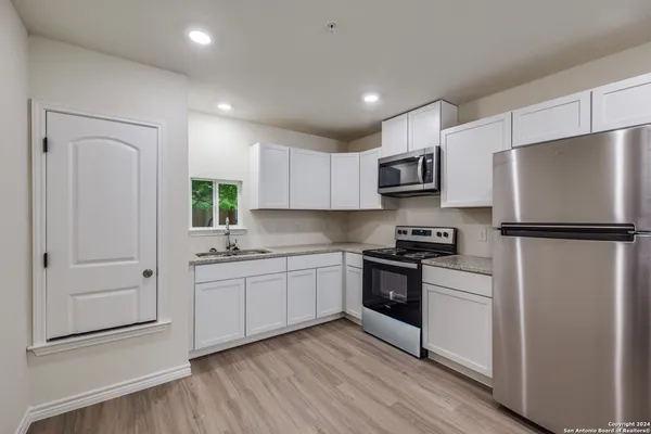 a kitchen with stainless steel appliances granite countertop a refrigerator and a stove top oven