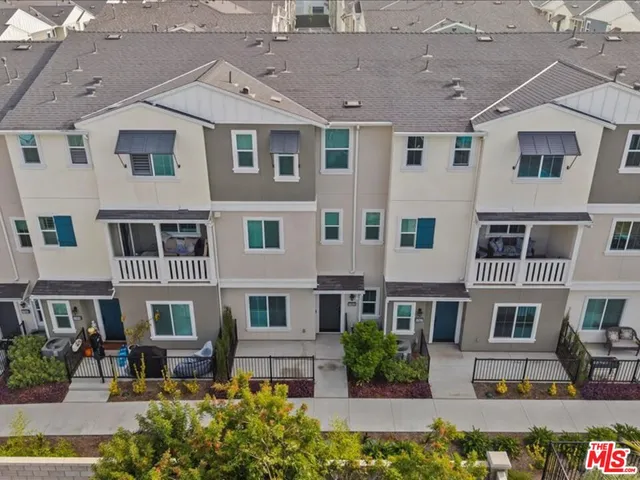 a front view of a building with garden and entryway
