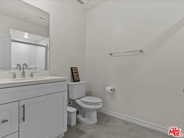 a bathroom with a toilet sink vanity and mirror