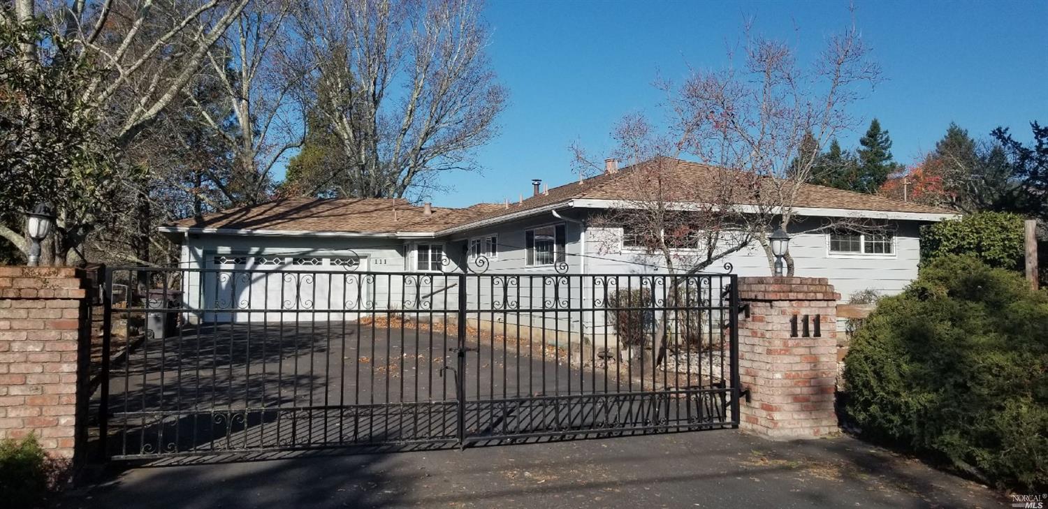 111 Frey Road Santa Rosa, CA 95409 - Photo 1 of 1 a view of a brick house with large trees and wooden fence