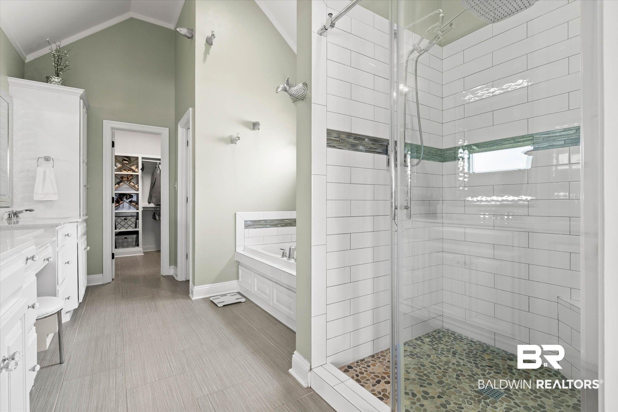 24908 Bosbyshell Avenue Daphne, AL 36526 - Photo 10 of 49 Glass-enclosed shower featuring white subway tile, a pebble floor, and a decorative tile accent band