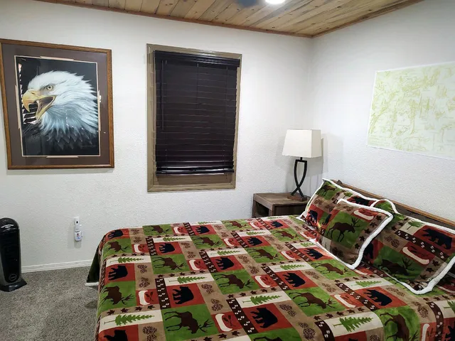 a bedroom with a bed and a lamp on dresser