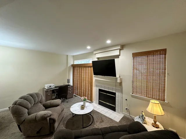 a living room with furniture a fireplace and a flat screen tv