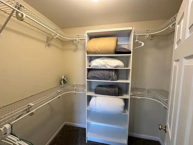 a room with a walk in closet and wooden floor