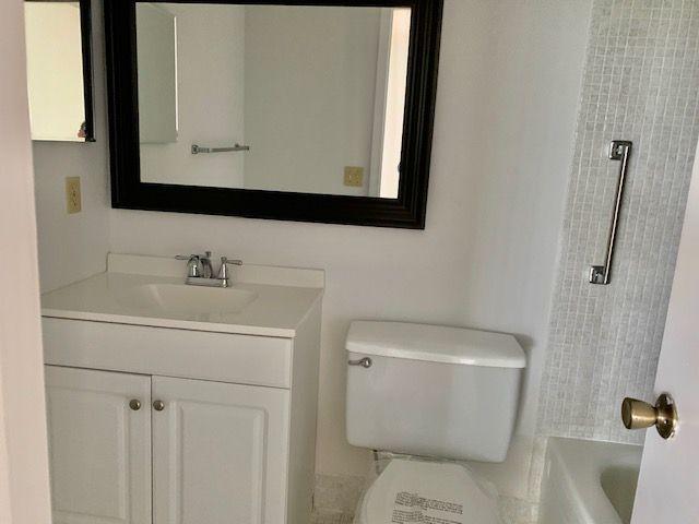 55 Mansfield B, Unit 55 Boca Raton, FL 33434 - Photo 9 of 19 a bathroom with a toilet sink and mirror