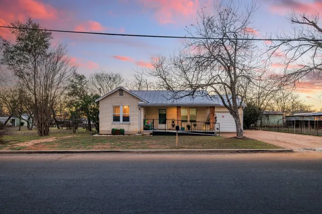 a yellow house with trees in front of it