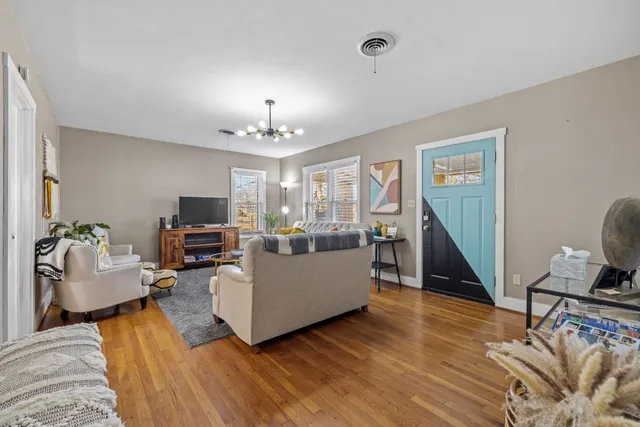 a living room with furniture and a wooden floor