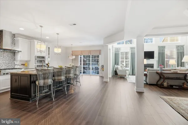 a kitchen with stainless steel appliances dining table chairs and wooden floor
