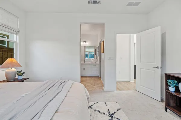 a bedroom with a bed and a refrigerator