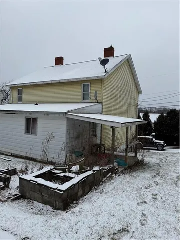 a backyard of a house with barbeque oven table and chairs