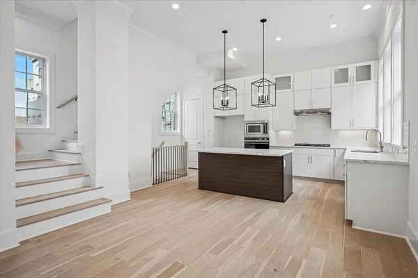 a large kitchen with stainless steel appliances granite countertop a large stove a sink dishwasher and a refrigerator with wooden floor