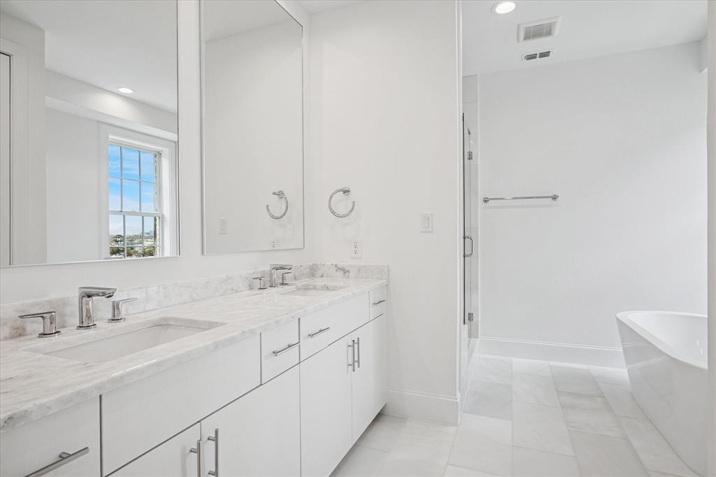 4070 Oak Circle Addison, TX 75001 - Photo 11 of 38 a bathroom with a double vanity sink a mirror and a bathtub