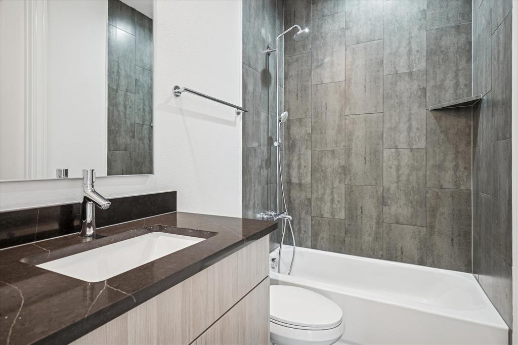 4070 Oak Circle Addison, TX 75001 - Photo 13 of 38 a bathroom with a granite countertop sink toilet and shower
