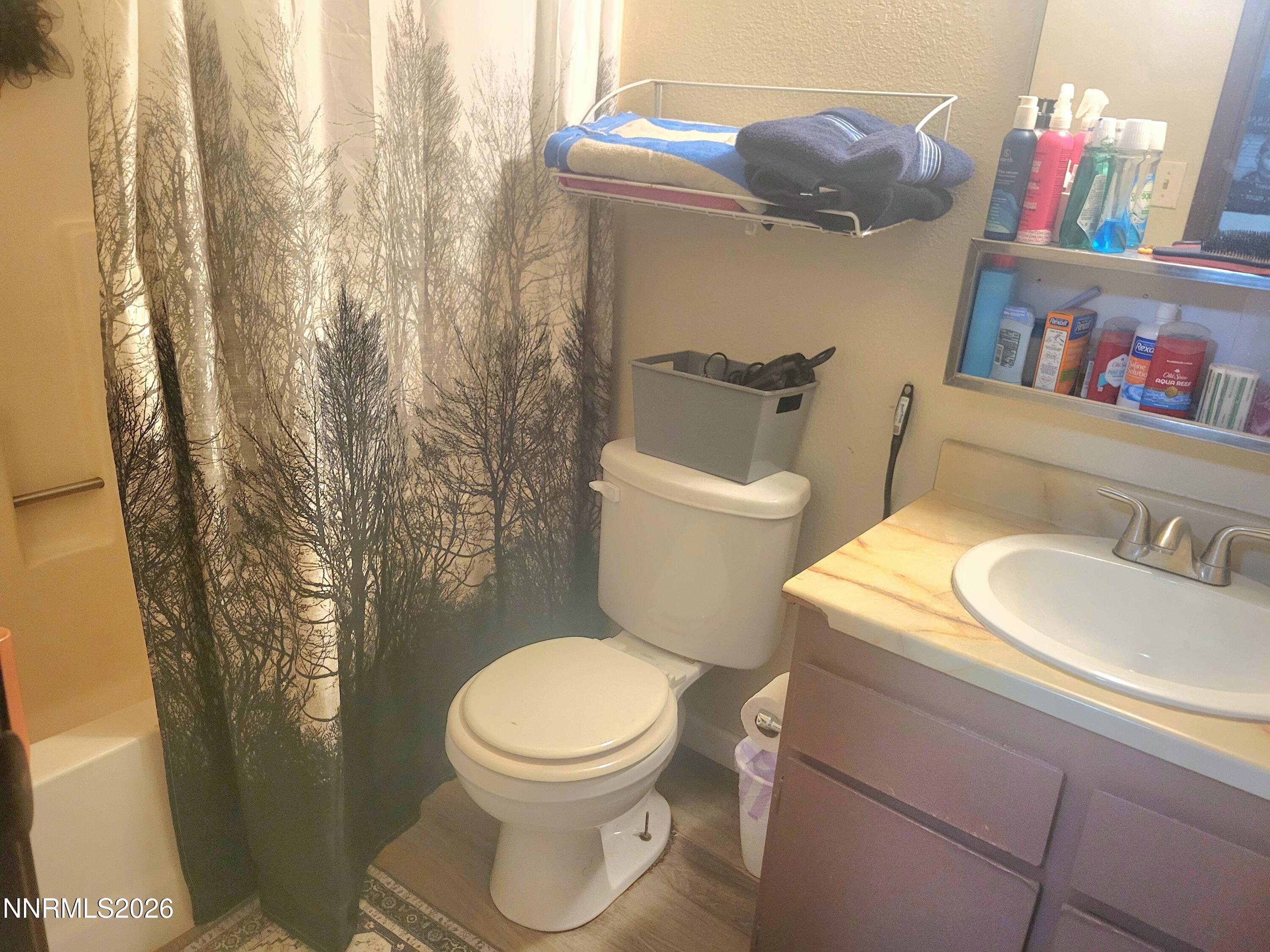 1404 East 9th Street, Unit 3 Reno, NV 89512 - Photo 21 of 29 a white toilet sitting next to a bathroom sink and vanity