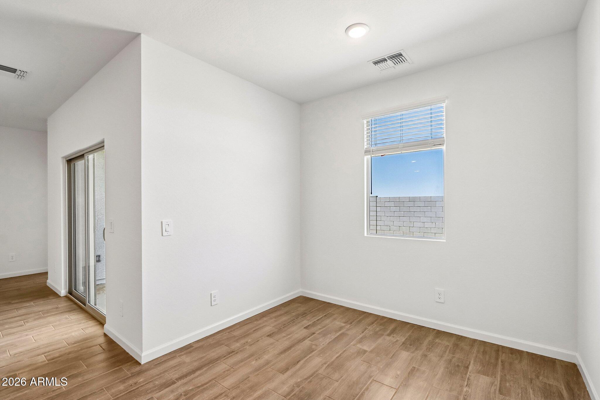 47624 West Moeller Road Maricopa, AZ 85139 - Photo 18 of 48 a view of an empty room with wooden floor and a window