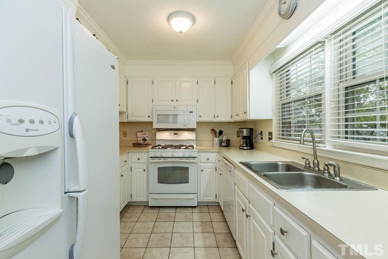 7811 Breckon Way Raleigh, NC 27615 - Photo 12 of 30 a kitchen with a sink stove and cabinets