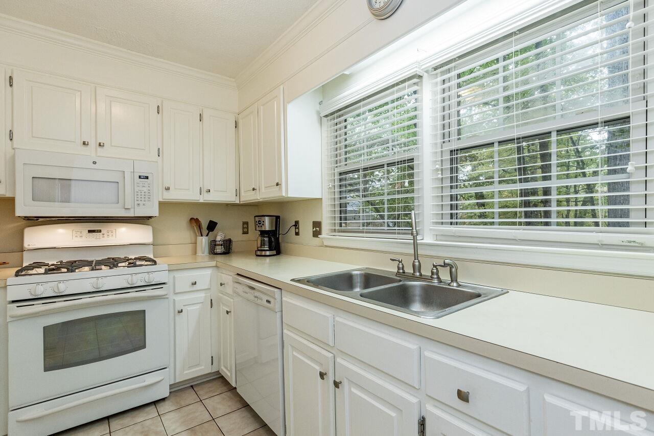 7811 Breckon Way Raleigh, NC 27615 - Photo 13 of 30 a kitchen with granite countertop a sink stainless steel appliances and cabinets