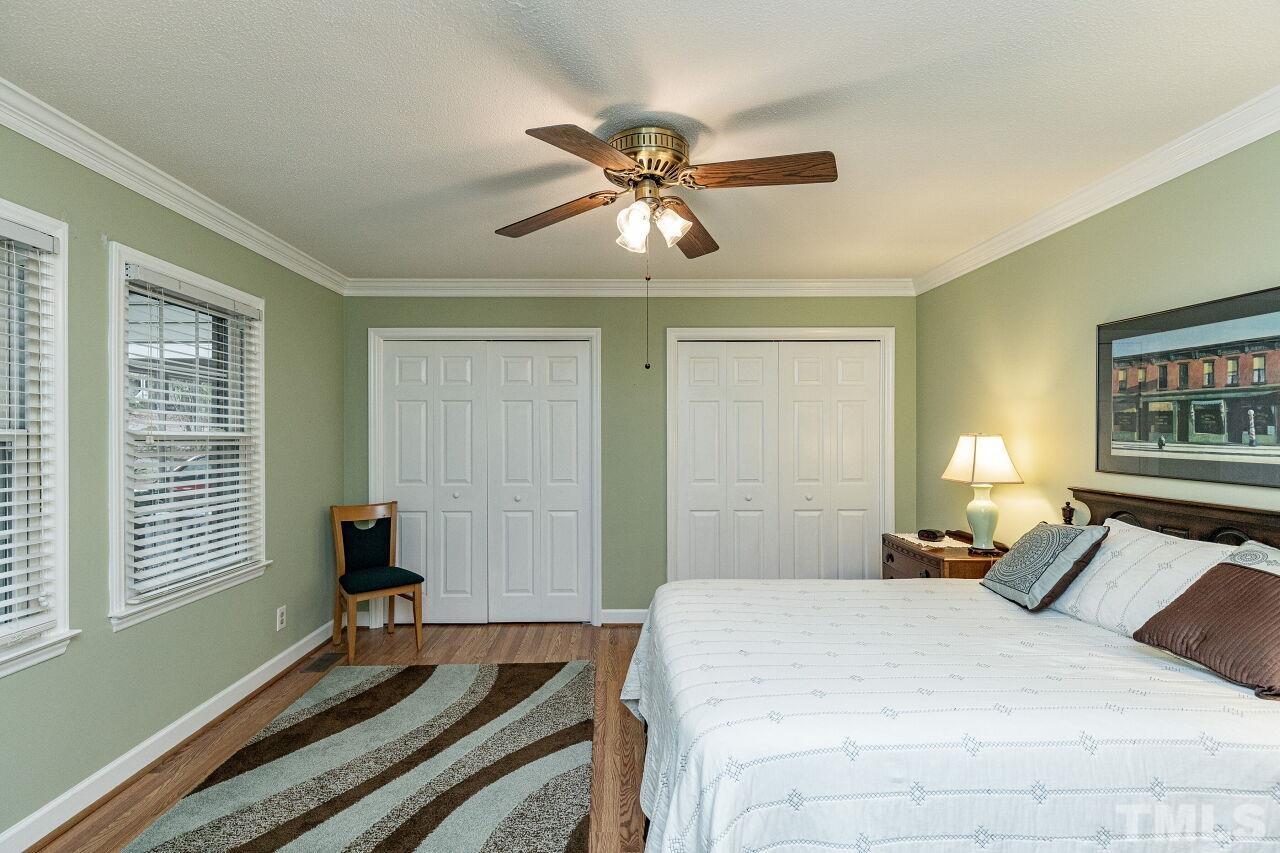 7811 Breckon Way Raleigh, NC 27615 - Photo 16 of 30 a bedroom with a bed and a chandelier