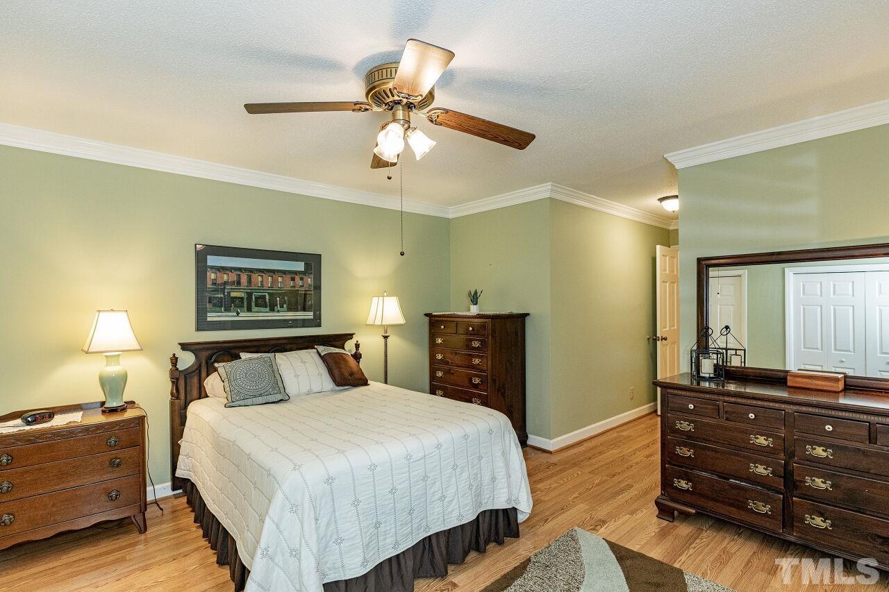 7811 Breckon Way Raleigh, NC 27615 - Photo 18 of 30 a bedroom with a bed and a dresser
