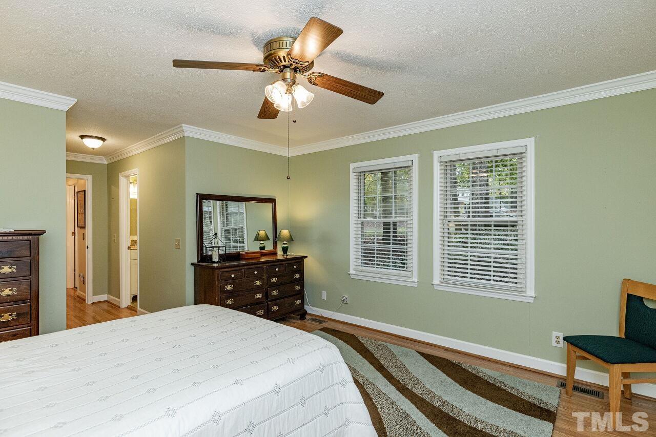 7811 Breckon Way Raleigh, NC 27615 - Photo 19 of 30 a bedroom with a bed and a dresser