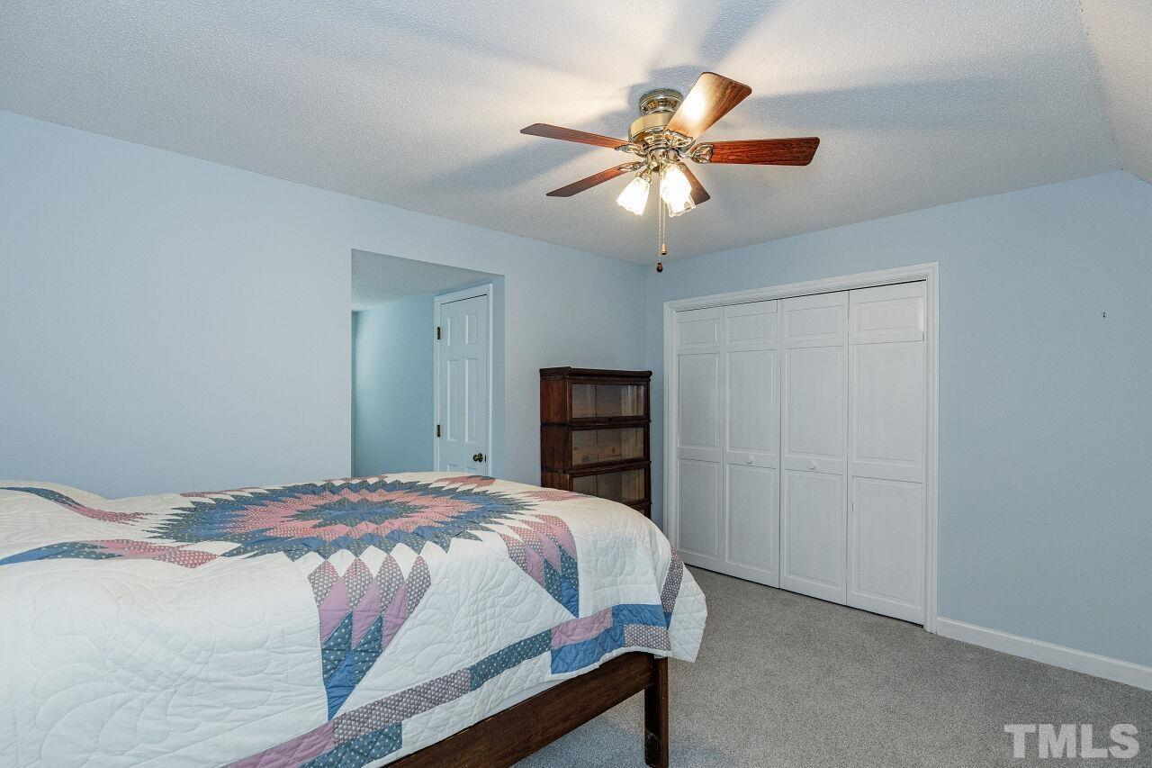 7811 Breckon Way Raleigh, NC 27615 - Photo 22 of 30 a bedroom with a bed and a chandelier