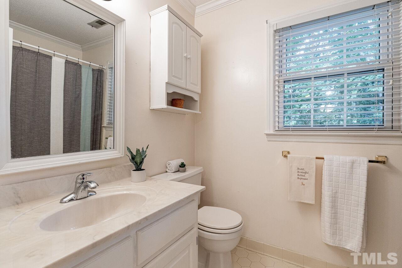 7811 Breckon Way Raleigh, NC 27615 - Photo 24 of 30 a bathroom with a sink toilet and shower