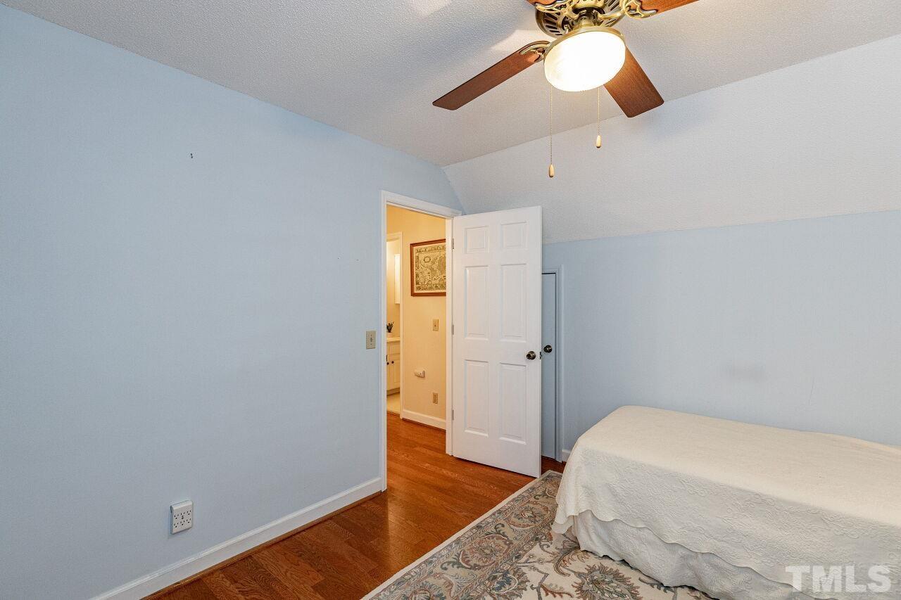 7811 Breckon Way Raleigh, NC 27615 - Photo 26 of 30 a bedroom with a bed and a chandelier